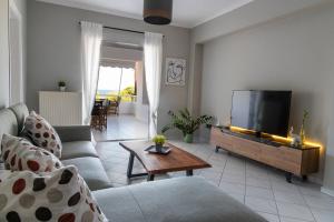 een woonkamer met een bank en een tv bij Chios BnB in Chios