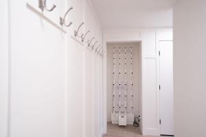 a hallway with white walls and white closets at Stoked 4Ever - Revelstoke Condo (+Hot Tub) in Revelstoke +29 photos