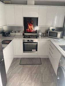 a kitchen with a stove and a fire in the oven at Family Home In The Forest Of Dean in Coleford