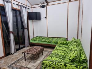 a room with two beds and a couch and a tv at Mika's House in Hanga Roa