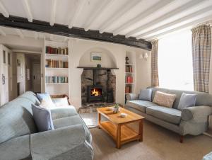 a living room with two couches and a fireplace at Plas in Rhoscolyn