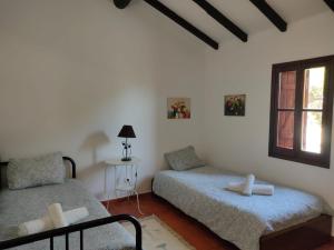 una camera da letto con due letti e una finestra di Monte Casa Nova Balsa ad Almograve