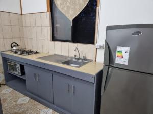a kitchen with a sink and a refrigerator at Mika's House in Hanga Roa