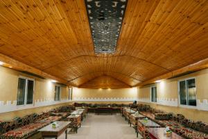 a large room with tables and chairs and a large wooden ceiling at Wadi Rum Desert Dunes Luxury Camp in Wadi Rum