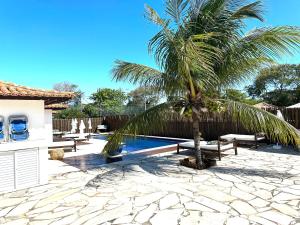uma palmeira sentada ao lado de uma piscina em Villa Ferradura Mar em Búzios
