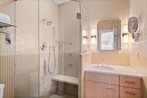 a bathroom with a shower and a sink and a mirror at Independence Square 304, Stylish Hotel Room with Downtown Views & Great Location in Aspen