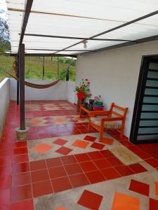 a patio with a table and a bench on a tile floor at Casa Campo La Milagrosa in Cómbita