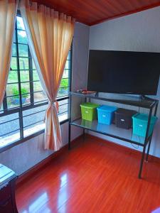 a living room with a television and two baskets on a table at Casa Campo La Milagrosa in Cómbita