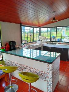 a kitchen with a counter and some yellow bar stools at Casa Campo La Milagrosa in Cómbita