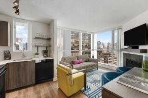 a living room with a couch and a kitchen with a large window at WorldMark Vancouver The Canadian in Vancouver