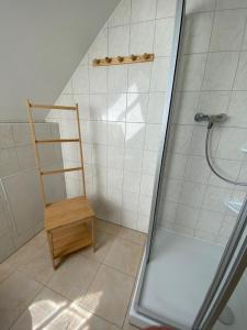une salle de bain avec douche et une chaise en bois dans l'établissement Ferienhaus am Gutspark 3, Klausdorf, ca 250 m bis zur Badestelle, à Klausdorf 25 autres photos