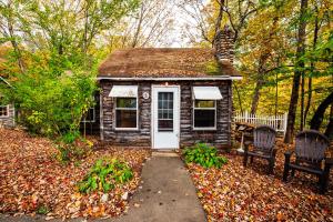 a small house with two chairs in the leaves at Pemi Cabins in Lincoln