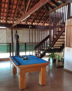 - une table de ping-pong dans une pièce avec un escalier dans l'établissement pousada santos, à Jacuí