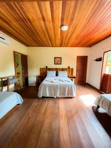 ein Schlafzimmer mit einem Bett und einer Holzdecke in der Unterkunft Pousada da Fonte in Lençóis