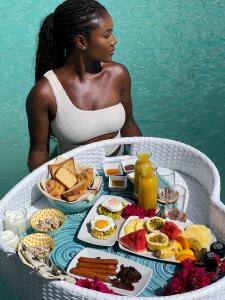 a woman sitting at a table with a tray of food at Imara Beach Resort in Kiwengwa
