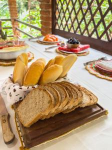 a table with a loaf of bread on a cutting board at Pousada da Fonte in Lençóis