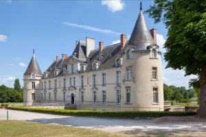 un grand château avec des tourelles en haut dans l'établissement Château d'Augerville Golf & Spa Resort, à Augerville-la-Rivière