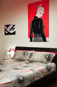 1 dormitorio con 1 cama con una pintura en la pared en Eva & Diabolik's Secret Room, en Milán