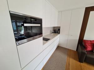 eine Küche mit weißen Schränken und einer Mikrowelle in der Unterkunft Haus Allod 205 in Lenzerheide
