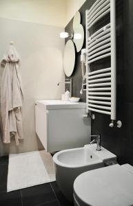 W łazience znajduje się umywalka, toaleta i lustro. w obiekcie Eva & Diabolik's Secret Room w Mediolanie