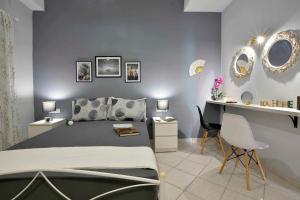 a bedroom with a bed and a desk with chairs at Casa Mia Apartment in Corfu