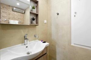 a bathroom with a white sink and a mirror at Casa Mia Apartment in Corfu +20 photos