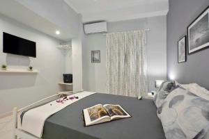 a bedroom with a bed with a book on it at Casa Mia Apartment in Corfu
