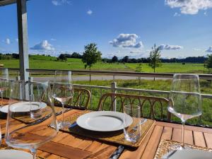 a table with wine glasses and a view of a field at SiOUX: Penthouse „BOHO“ mit traumhaftem Ausblick in Leutkirch im Allgäu