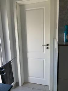 a white door in a room with a kitchen at Messe Apartment in Hannover