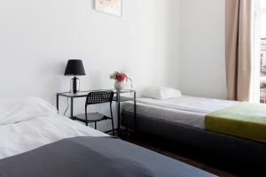 ルブリンにあるホステル クロレフスカのベッドルーム1室(ベッド2台、デスク、椅子付)