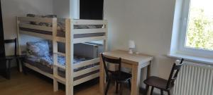 a room with a bunk bed and a table and a desk at Gasthaus Bikertreff in Gablingen