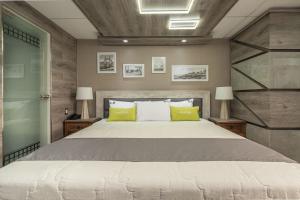 1 dormitorio con 1 cama grande con almohadas verdes en Hotel El Marqués, en Lima