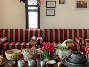 a living room with a red and white striped couch at Golden Palm Oasis in Fulayj al Mashāʼikh
