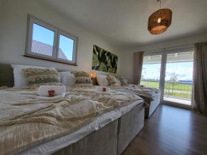 a bedroom with two beds and a large window at SiOUX: Penthouse „BOHO“ mit traumhaftem Ausblick in Leutkirch im Allgäu