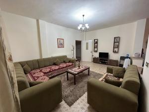 馬達巴的住宿－Alice & Andrew Apt. Few Steps to Madaba Old City Center，客厅配有沙发和桌子