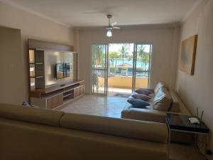 a living room with a couch and a television at Apartamento de Frente para o Mar in Ubatuba