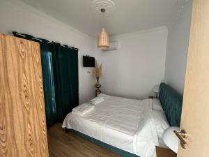 1 dormitorio con 1 cama y cortina verde en 360ᵒ Lepanto Apartment, en Nafpaktos