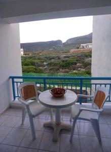 a table and chairs on a balcony with a view at Athena Kythera in Dhiakofti