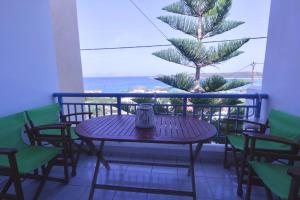 a table with a clock sitting on top of a balcony at Athena Kythera in Dhiakofti