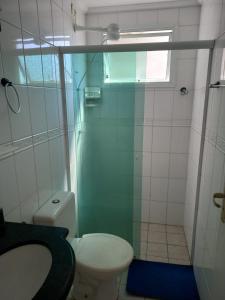 a small bathroom with a toilet and a shower at Apartamento de Frente para o Mar in Ubatuba