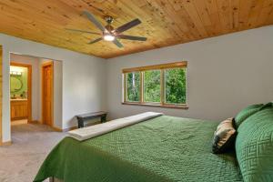 Schlafzimmer mit einem grünen Bett und einem Deckenventilator in der Unterkunft Secluded Mtn home by Purg, Hot Tub, Views! Pets ok in Durango