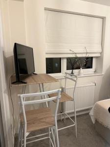 Cette chambre comprend un bureau avec un ordinateur et une fenêtre. dans l'établissement Studioflat in the heart of Chelsea, à Londres