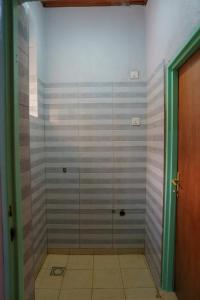 une douche avec une porte vitrée dans une pièce dans l'établissement Family Oasis, à Kigali 35 autres photos
