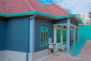 un modèle de maison bleue avec un toit rouge dans l'établissement Family Oasis, à Kigali