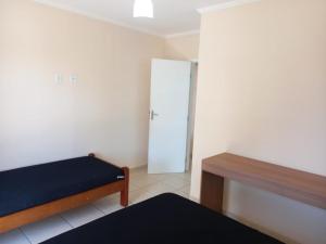 a bedroom with a bed and a closet and a door at Apartamento de Frente para o Mar in Ubatuba