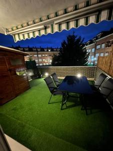 a patio with a table and chairs on the grass at Jumeke Home in Castro-Urdiales