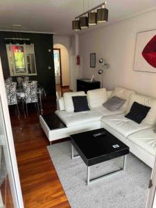 a living room with a white couch and a table at Jumeke Home in Castro-Urdiales