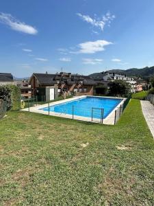 a large swimming pool in a yard with houses at Jumeke Home in Castro-Urdiales