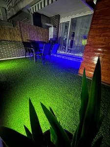 Jumeke Home في كاسترو أورديالس: أرضية خضراء في غرفة مع كراسي وطاولة