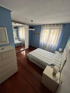 een slaapkamer met een bed en een blauwe muur bij Jumeke Home in Castro-Urdiales